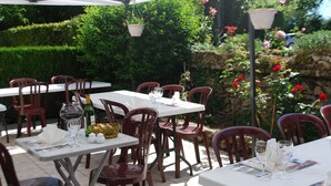 An outdoor dining area with tables and chairs, surrounded by greenery and flowers. - Le Ranch des Lacs, Hôtel Restaurant à Augne (Augne)