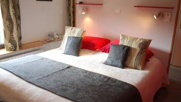 A neatly made bed with a white duvet, two pillows, and a grey throw.