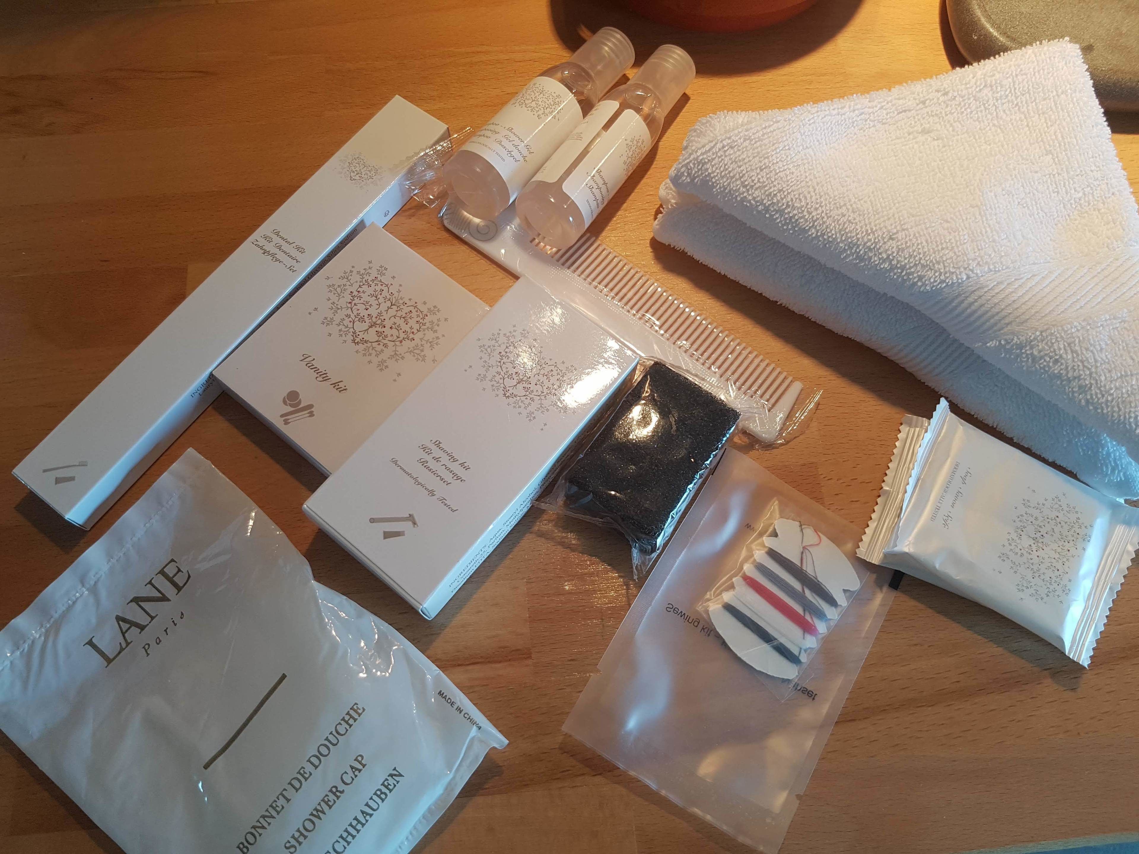 A bathroom vanity with a white countertop, a white towel, and a bottle of hand soap.