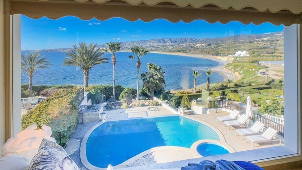 Una piscina con vistas al mar y colinas.