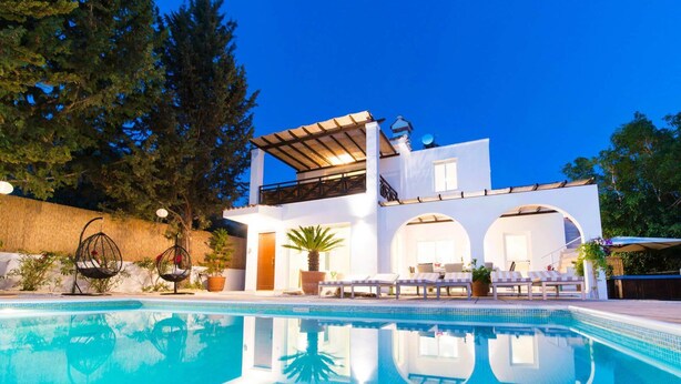 Una moderna casa a due piani con piscina, area relax all'aperto e un pergolato.