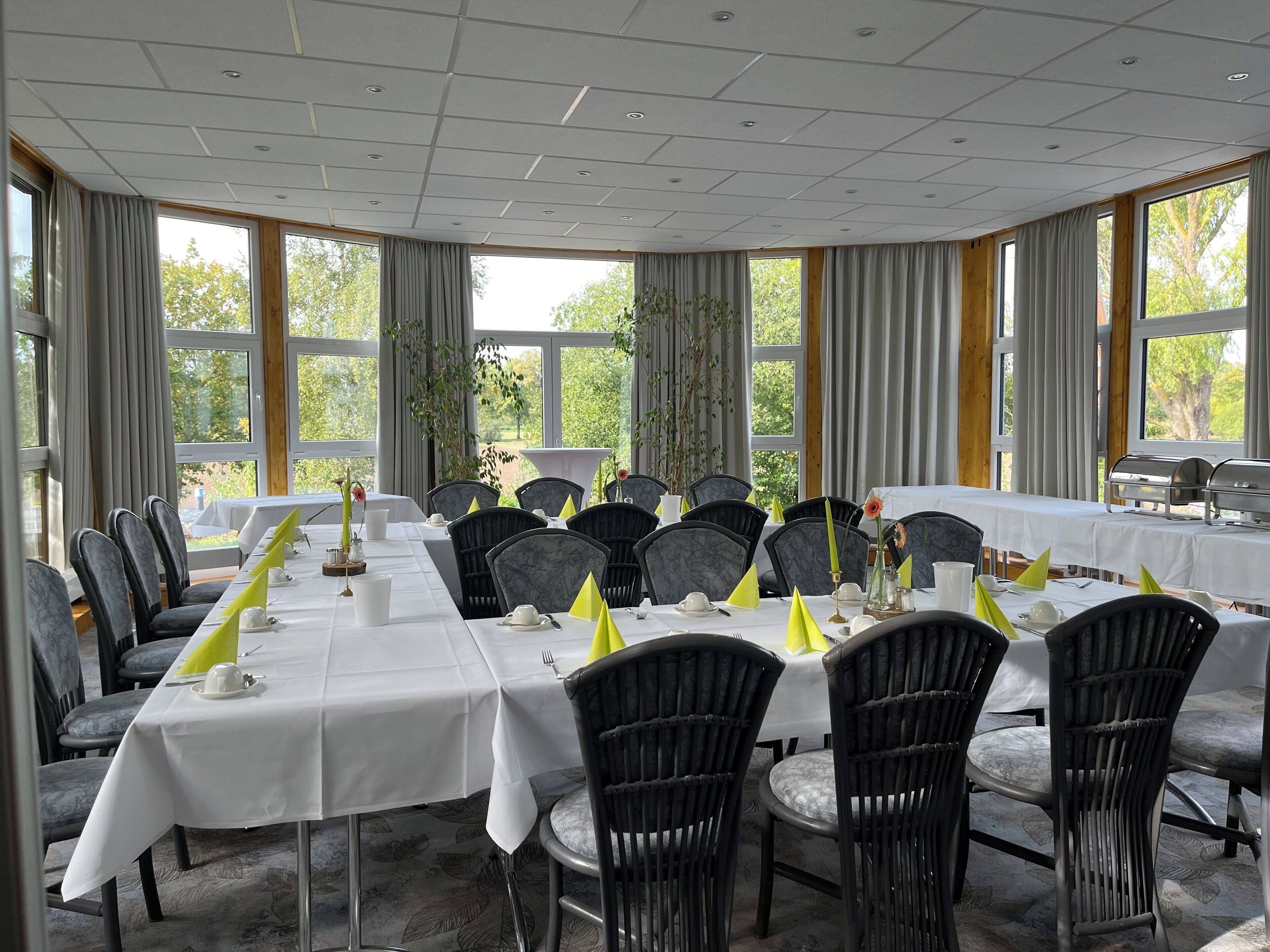 A conference room with a long table, chairs, and a buffet setup.