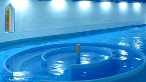 An indoor swimming pool with a central circular feature and a straight section. - Hotel Aquarius (Braunschweig)