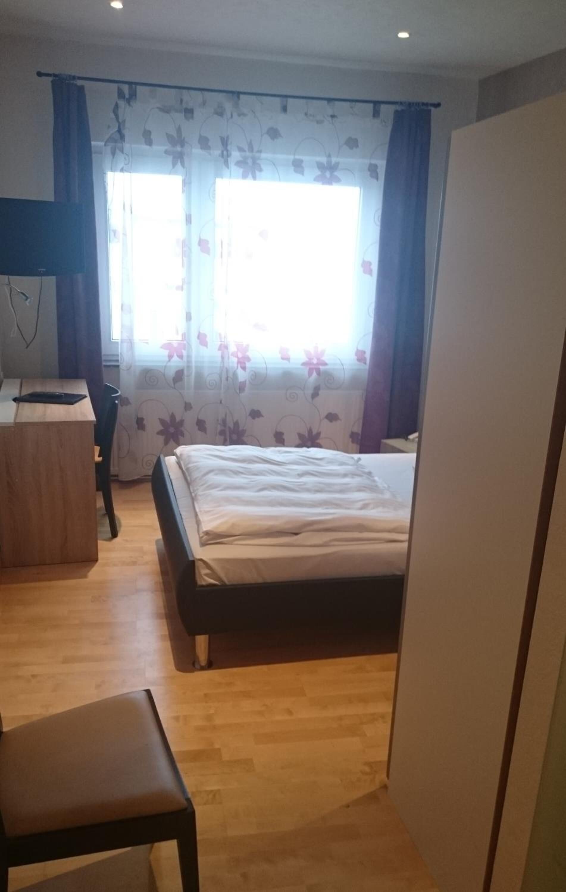 Una habitación de hotel con una cama, un escritorio y una silla.