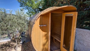 A wooden cabin with a curved roof, a door, and a window. - Les Gargoulettes (Lauris)