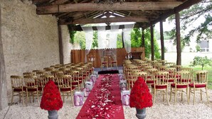 An outdoor wedding venue with rows of golden chairs, a red carpet, and flower arrangements. - Chateau Pontet d'Eyrans & Spa (Eyrans)