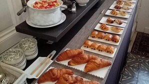 A buffet table with various food items, including fruits, croissants, and a bowl of mixed vegetables. - Hôtel la Tour Perrier (Eyrans)