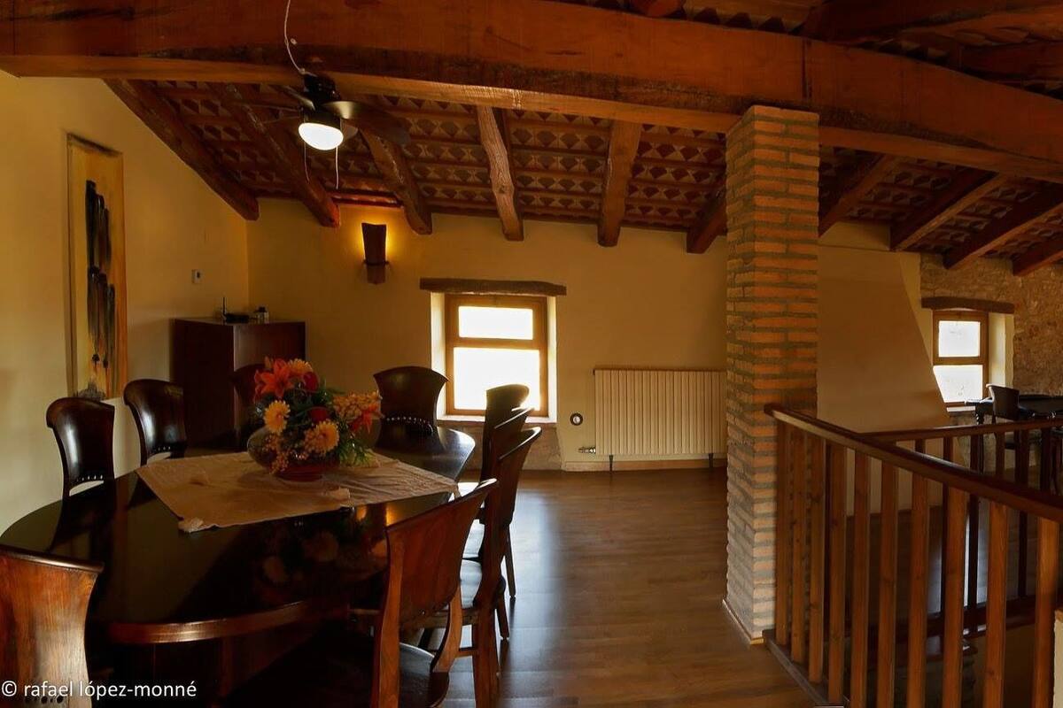 A spacious interior with a wooden dining area, a kitchen, and a living area with a balcony.