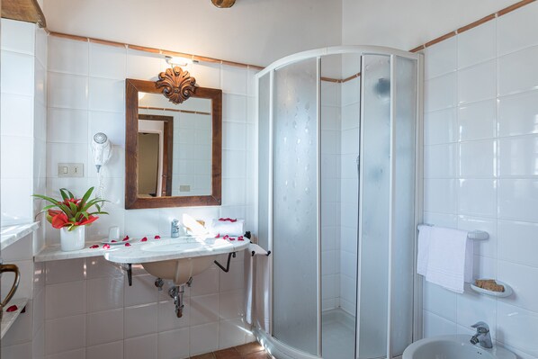 A bathroom with a white sink, mirror, and shower. - Il Poderino (Castellina in Chianti)