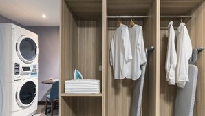 A modern laundry room with a front-loading washing machine, a drying rack, and neatly folded towels. - Ibis Styles Kuala Lumpur Bukit Bintang (Kuala Lumpur)