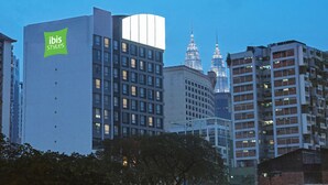A modern hotel with a prominent 'ibis styles' sign, surrounded by other buildings and a clear sky. - Ibis Styles Kuala Lumpur Bukit Bintang (Kuala Lumpur)