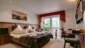 Una habitación de hotel moderna con una cama grande, un escritorio y un televisor.