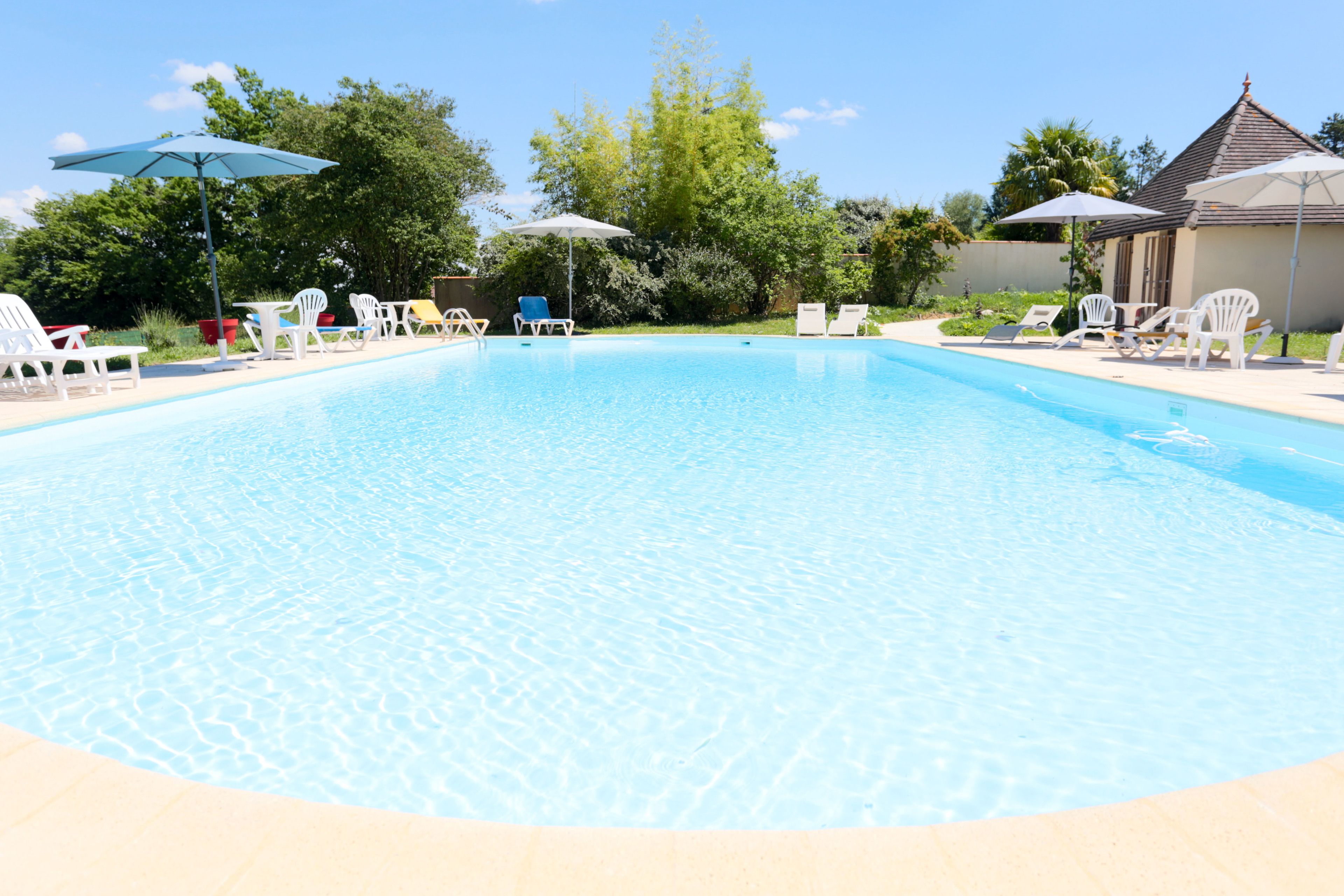 Een seizoensgebonden buitenzwembad, parasols voor strand/zwembad
