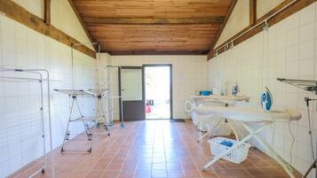 Un cuarto de lavandería con planchas, un tendedero y una lavadora.