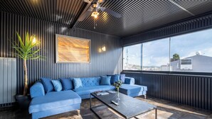 Una sala de estar moderna con un sofá seccional azul, una mesa de centro y una planta en maceta.