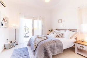 Un dormitorio con cama, mesita de noche y una silla.