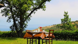 Una mesa al aire libre con vista al mar y a las colinas.