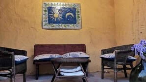 A rustic room with a wooden ceiling, a mural on the wall, a bench, and two chairs. - B&B Domu Incanto (Muravera)