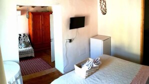 A bedroom with a bed, a television, a wardrobe, and a small table. - B&B Domu Incanto (Muravera)