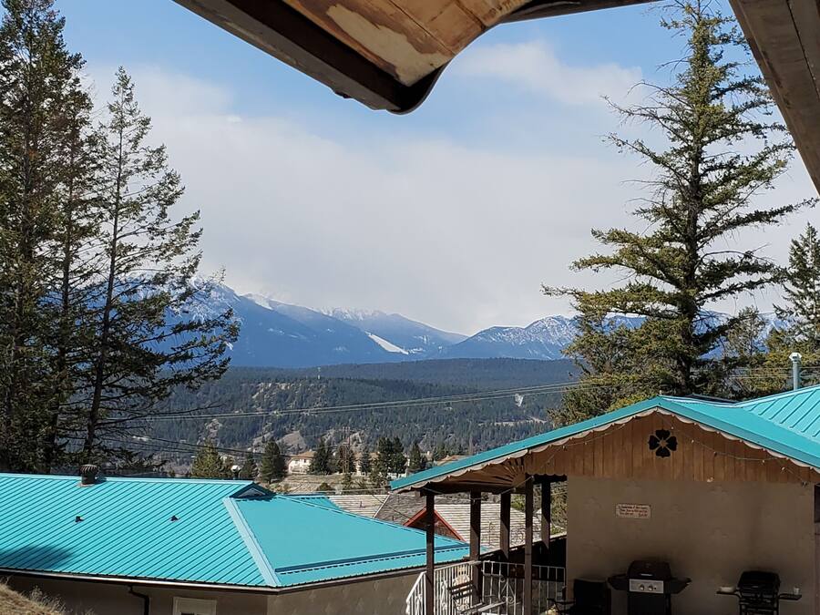 A mountain view with a building featuring a blue roof and a covered porch area.