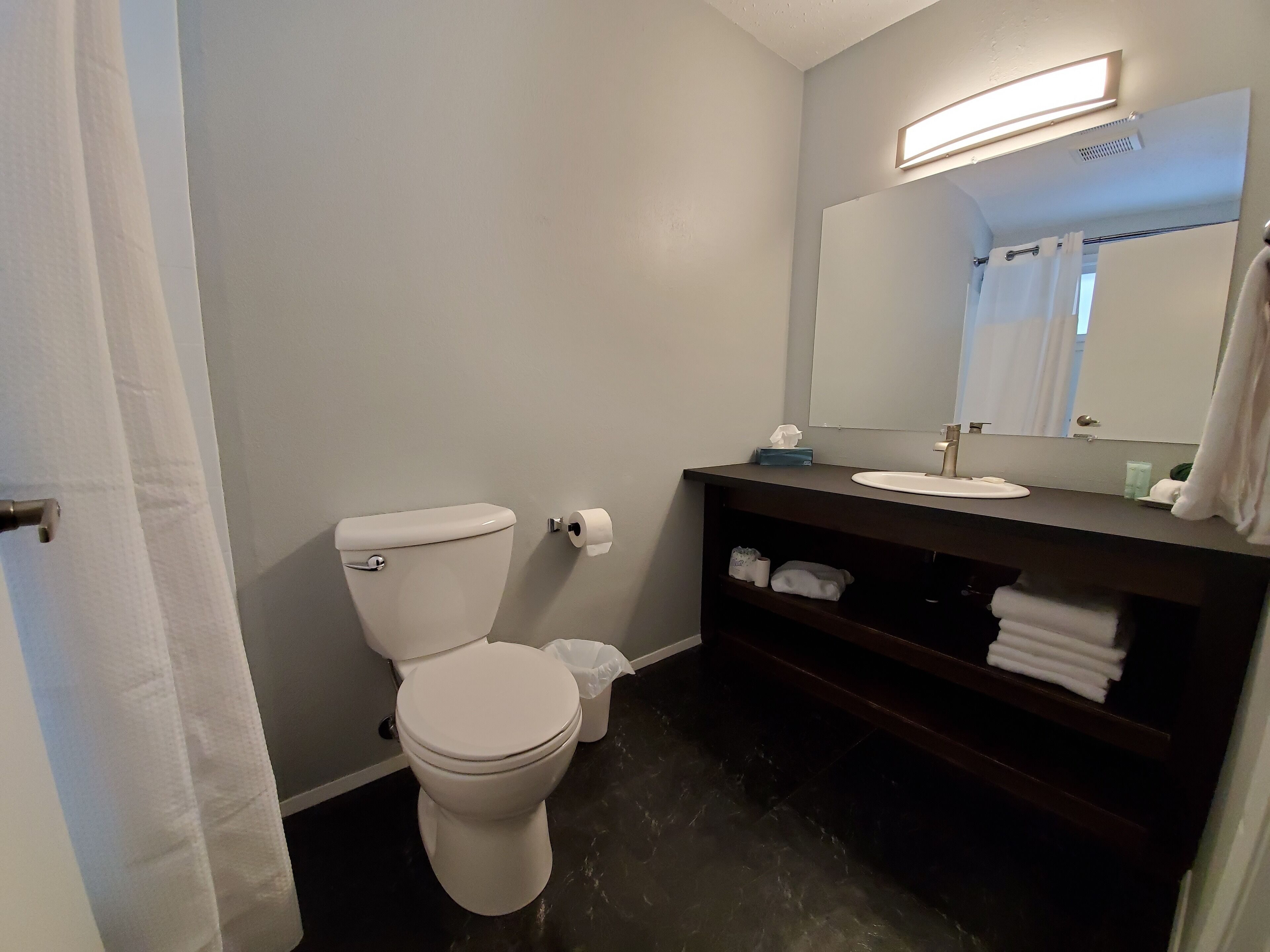 Un bagno con il water, un lavandino e uno specchio.