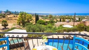A balcony with a pool, overlooking a coastal landscape with houses and greenery. - Villa Luna (Pegeia)