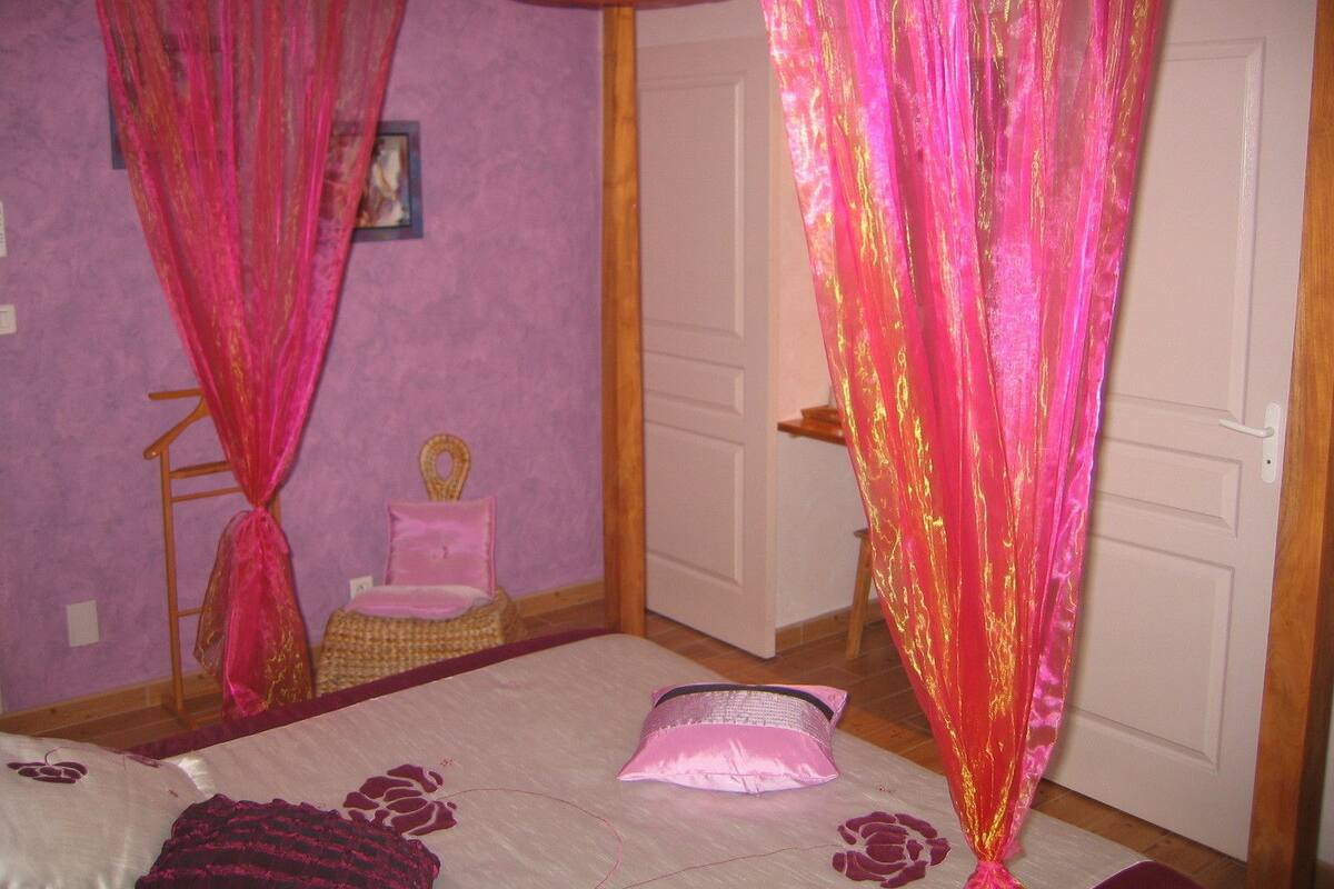 Un dormitorio con una cama, una silla y una puerta.