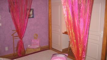A bedroom with a bed, a chair, and a door.