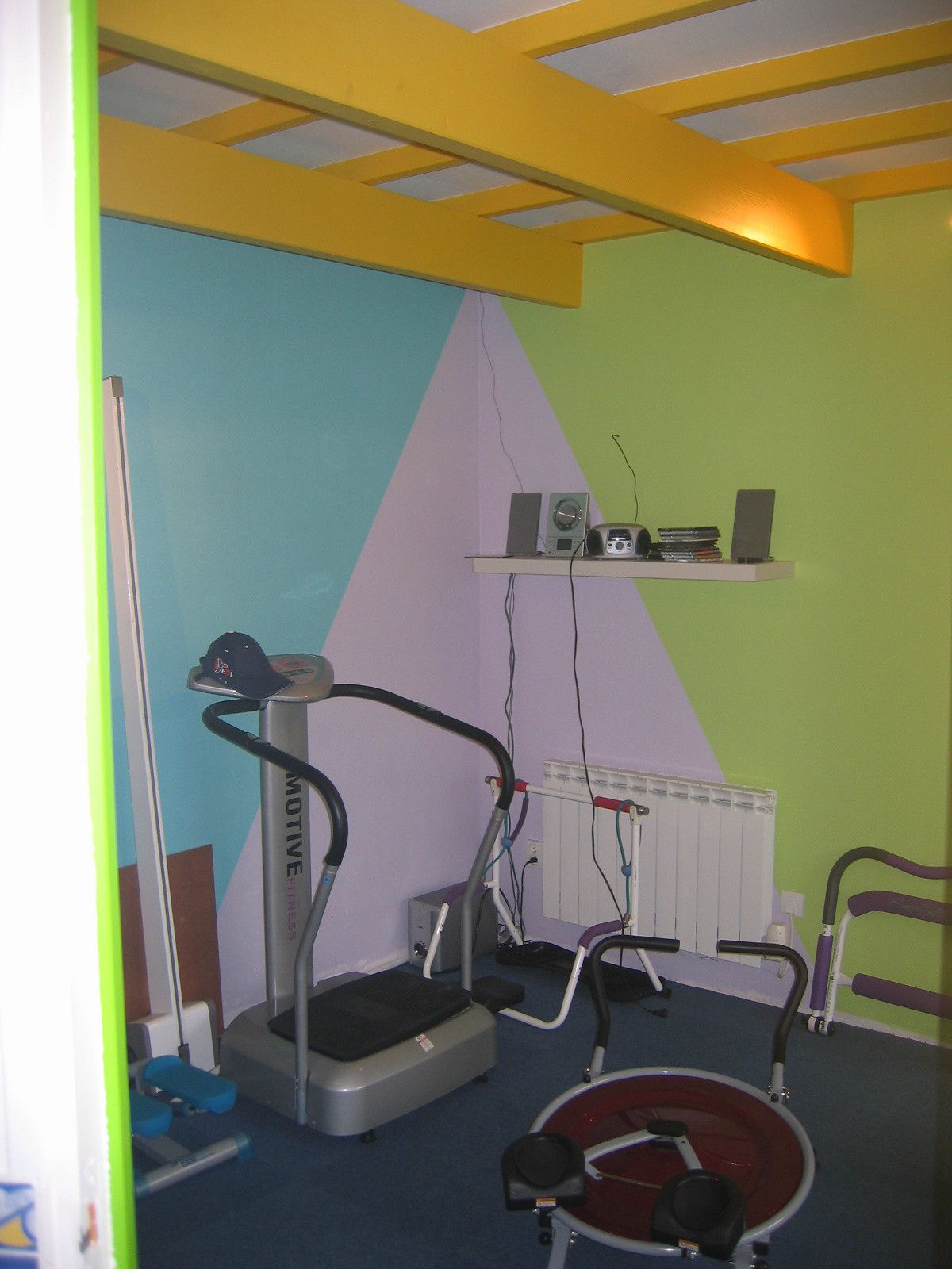 Un gimnasio con cinta de correr, elíptica y bicicleta estática.