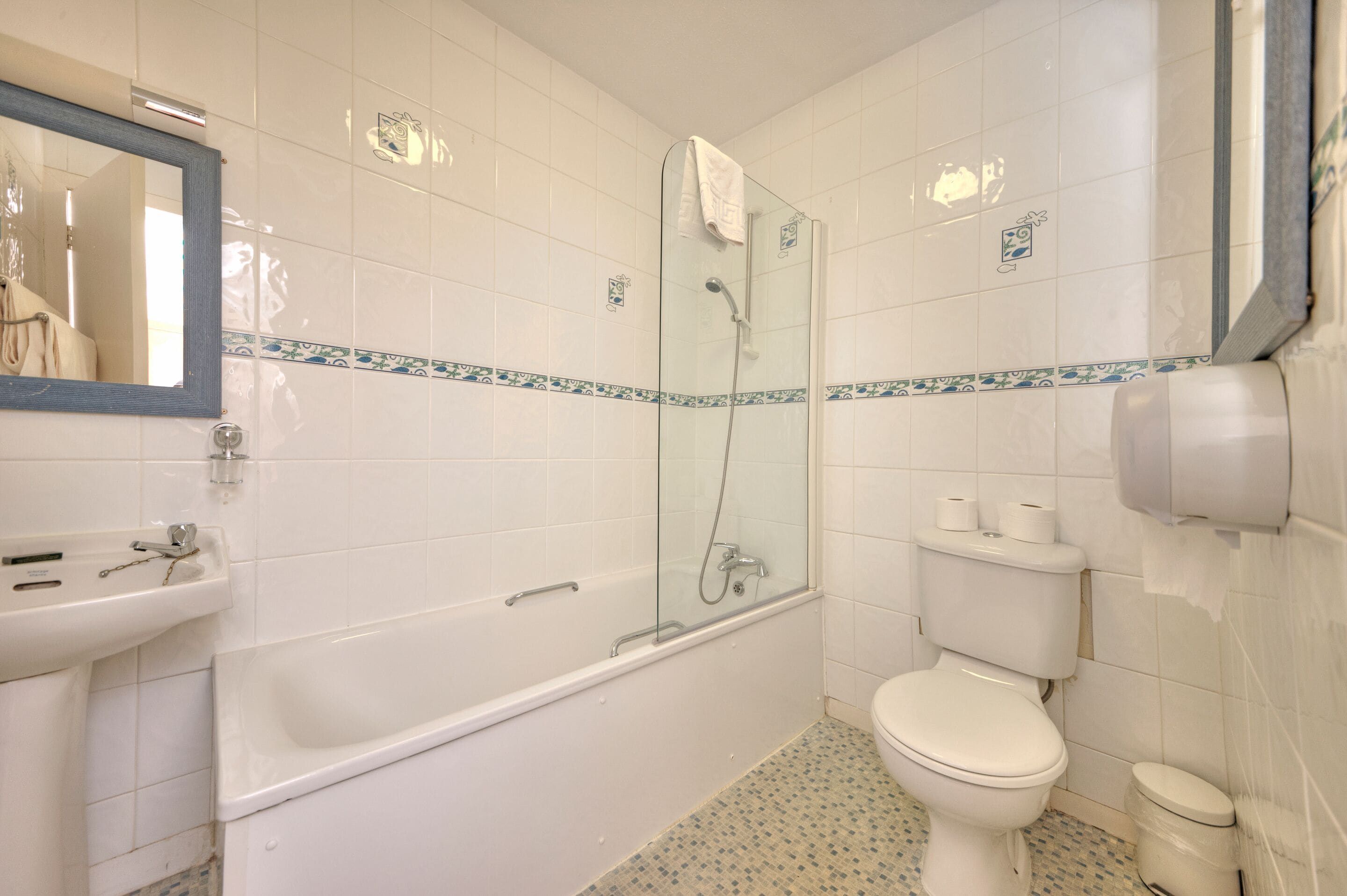 A bathroom with a bathtub, toilet, and sink.