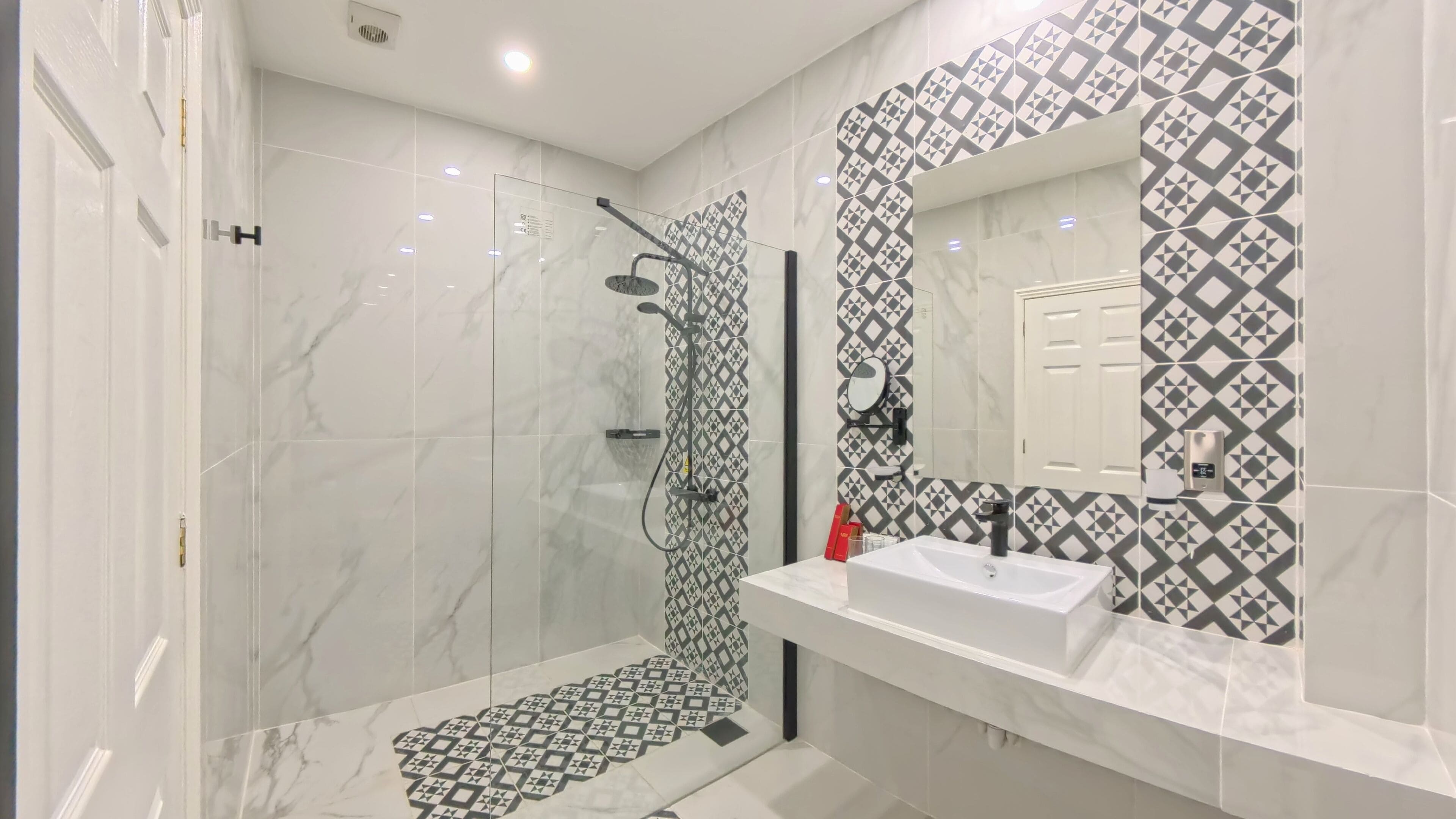Un baño moderno con ducha, lavabo y espejo.