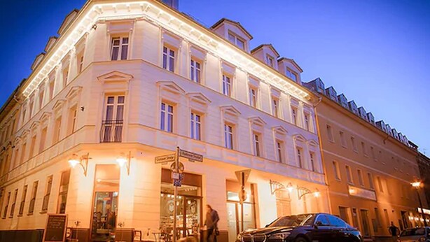A historic building with classical architecture, featuring a prominent corner entrance and a well-lit facade. - Bett & Buch Hotel (Berlin)