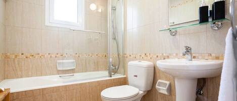 A modern bathroom with a bathtub, toilet, and sink.