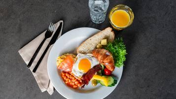 Un plato de desayuno con huevos, tocino, tostadas y verduras.