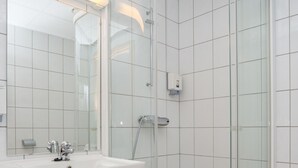 A modern bathroom with a glass-enclosed shower, a white sink, and a large mirror. - Best Western Hotel Alta (Alta)