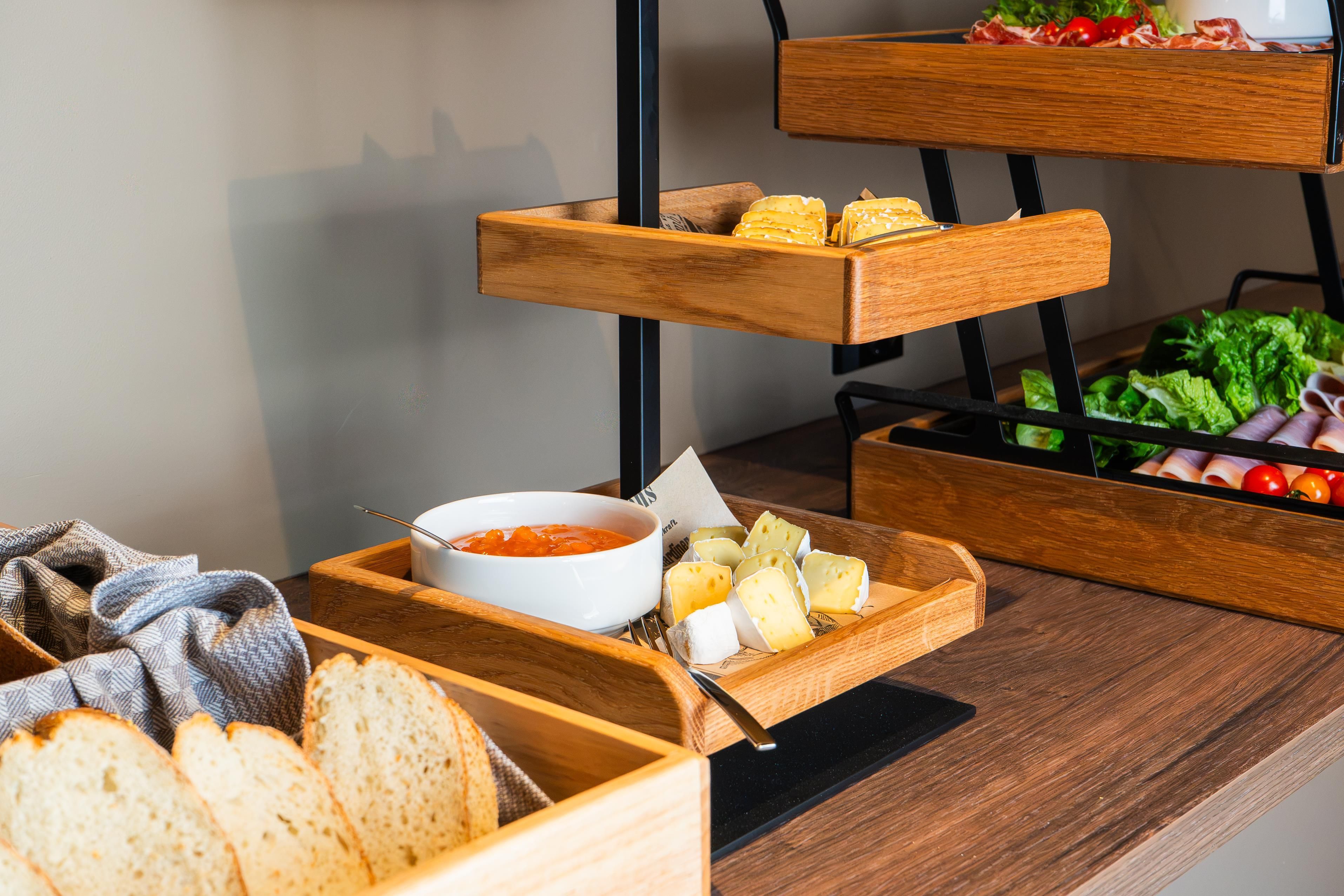 A buffet setup with various food items including bread, cheese, and vegetables.