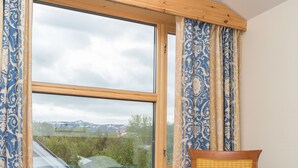A room with a large window, a wooden chair, a small round table, and a bed with a patterned bedspread. - Best Western Hotel Alta (Alta)