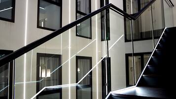 A modern building with a glass staircase and multiple windows.