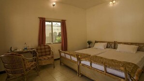 Una habitación con cama, una silla, un escritorio y una ventana.