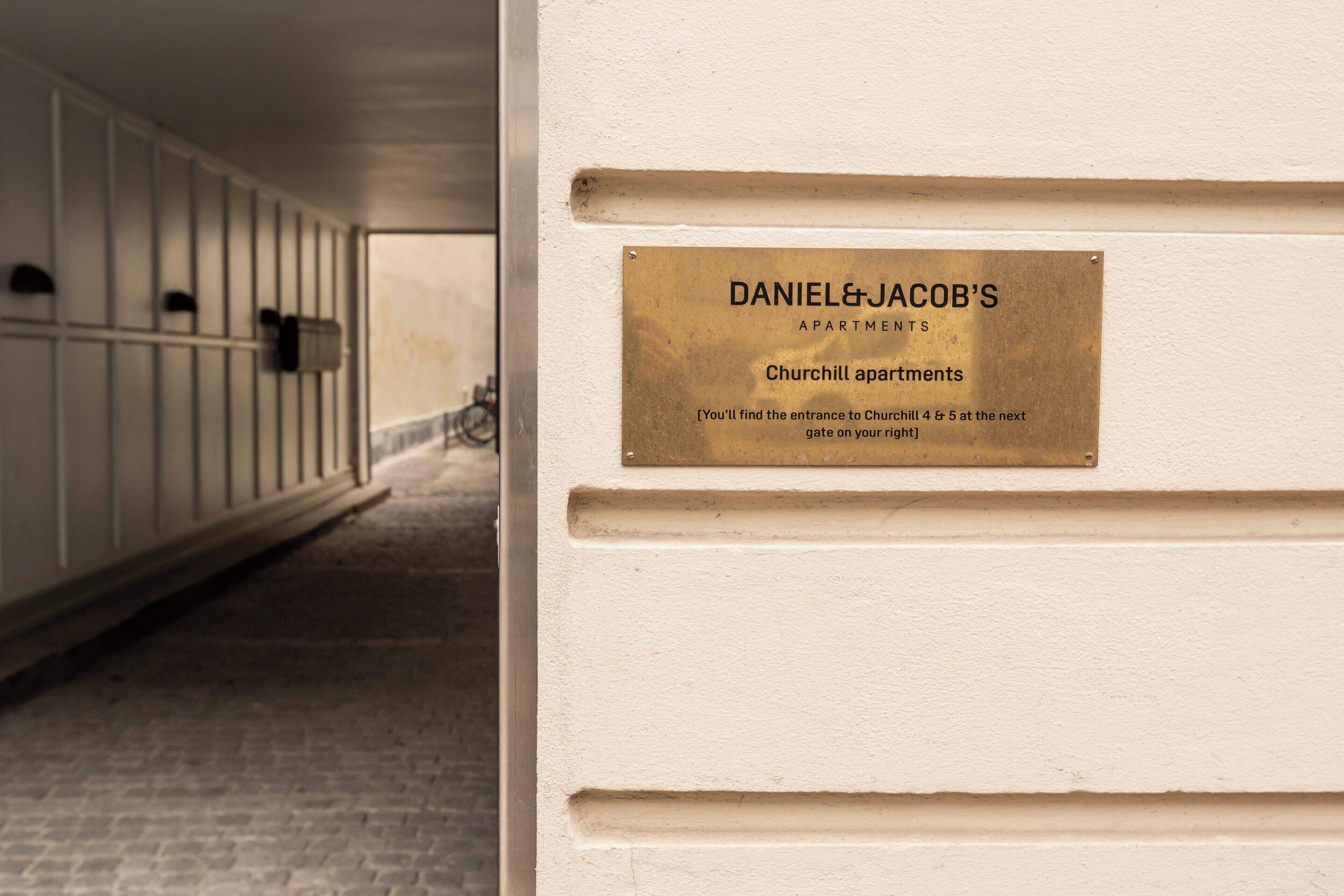 A hallway with a plaque indicating 'Daniel & Jacob's Apartments' and a sign for 'Churchill Apartments.'