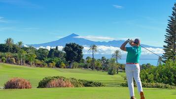 Un parcours de golf offrant une vue sur la montagne et l’océan.