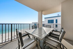 Balcón con mesa y sillas con vista a la playa.