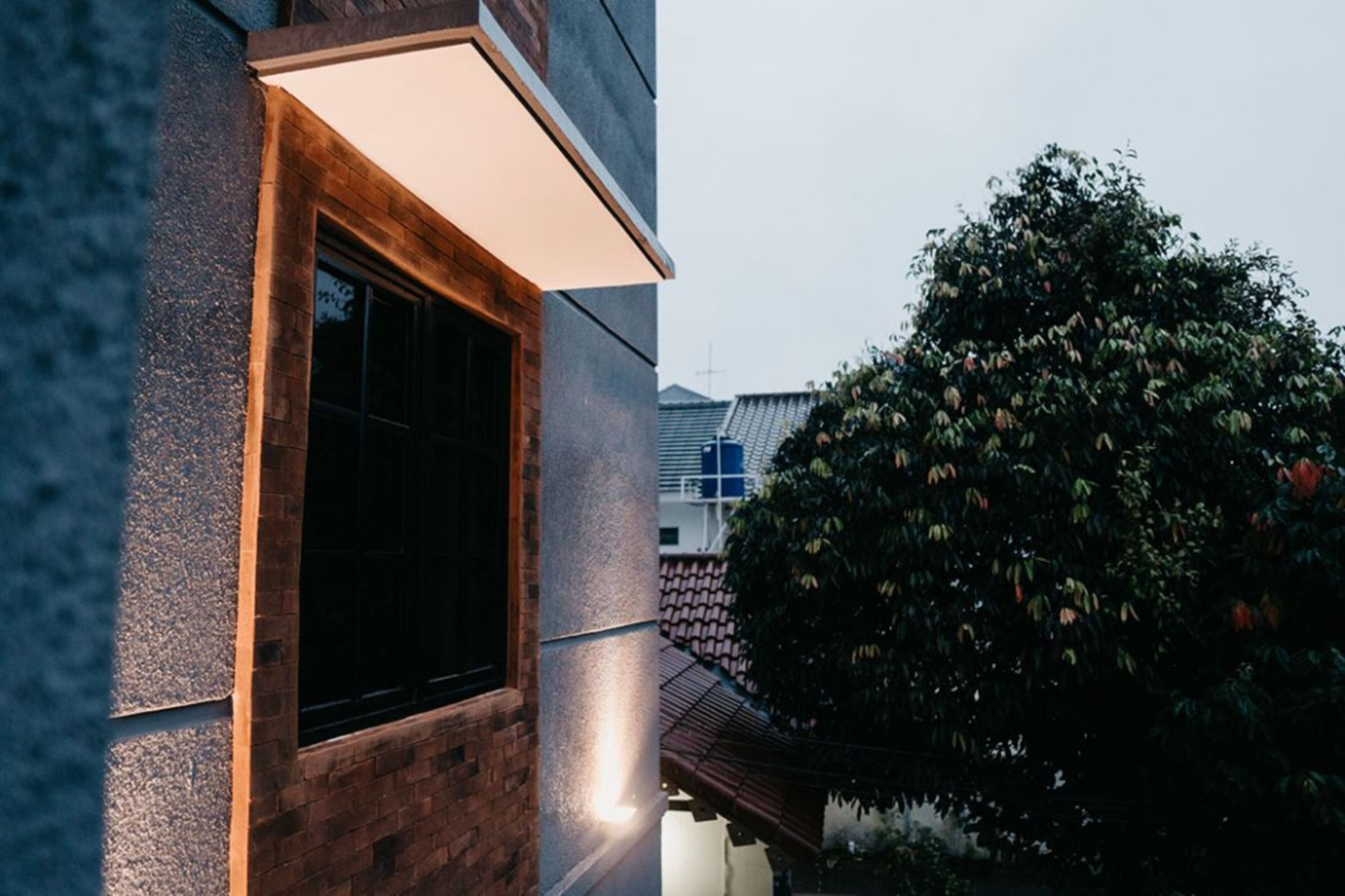 Un edificio con un ventanal grande y un aplique de pared.