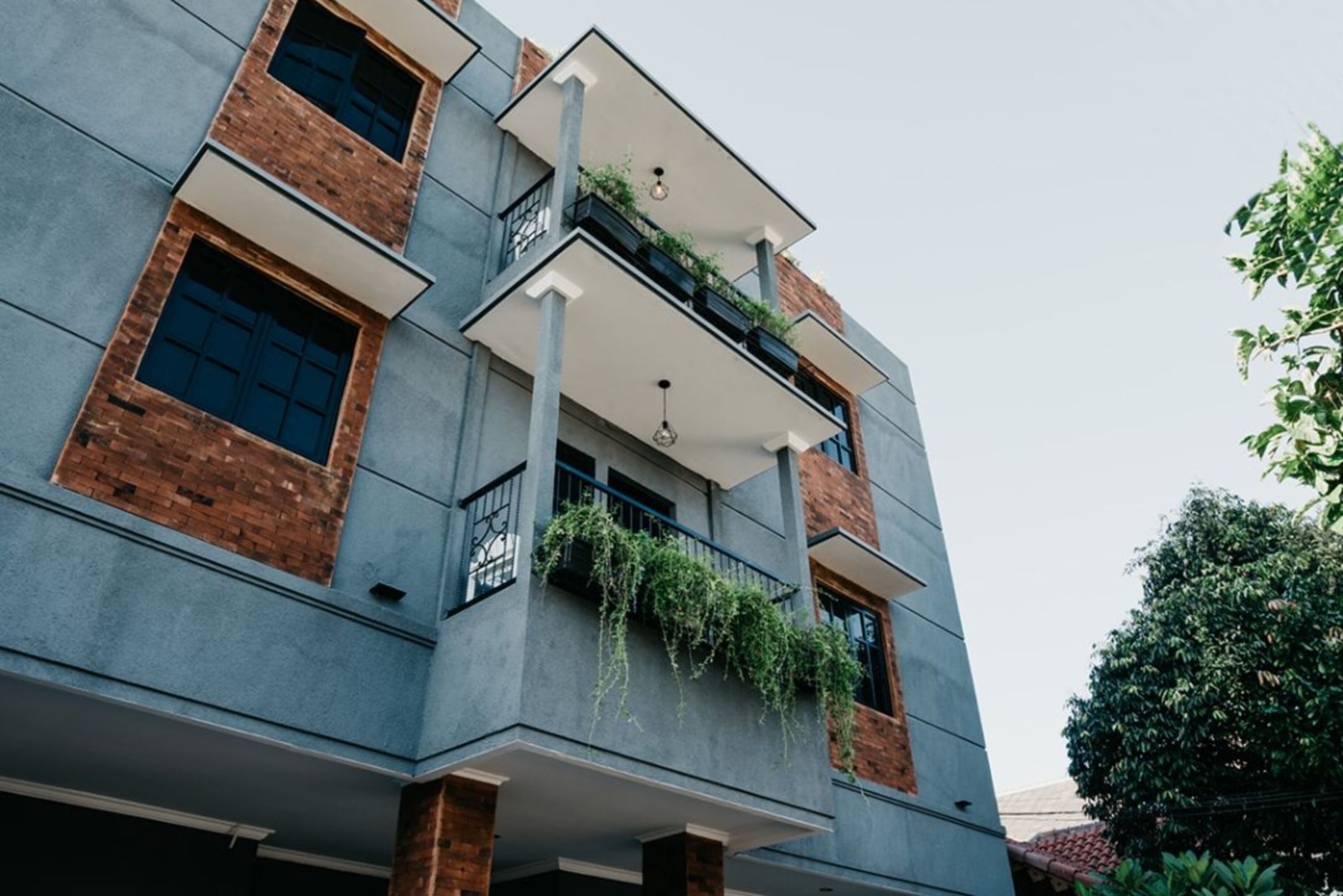 Un immeuble à plusieurs étages, doté d’un style architectural moderne, caractérisé par des murs en briques apparentes et de grandes fenêtres.