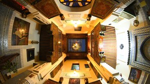 A room with a central stained glass window, patterned walls, and a chandelier. - Riad Dar Fes (Fes)