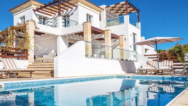 A modern two-story house with a swimming pool, outdoor seating, and a pergola. - Villa Porto (Pegeia)