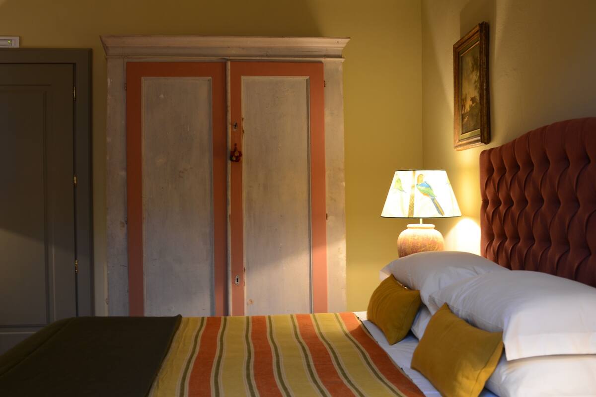 Ein Hotelzimmer mit einem Bett, einem Nachttisch mit Lampe und einem Kleiderschrank.