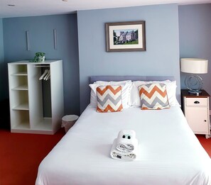 A hotel room with a bed, a wardrobe, a bedside table with a lamp, and a framed picture on the wall. - The Grey Horse (Darlington)
