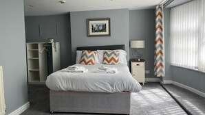 A neatly arranged bedroom with a bed, bedside table, lamp, and a picture on the wall. - The Grey Horse (Darlington)