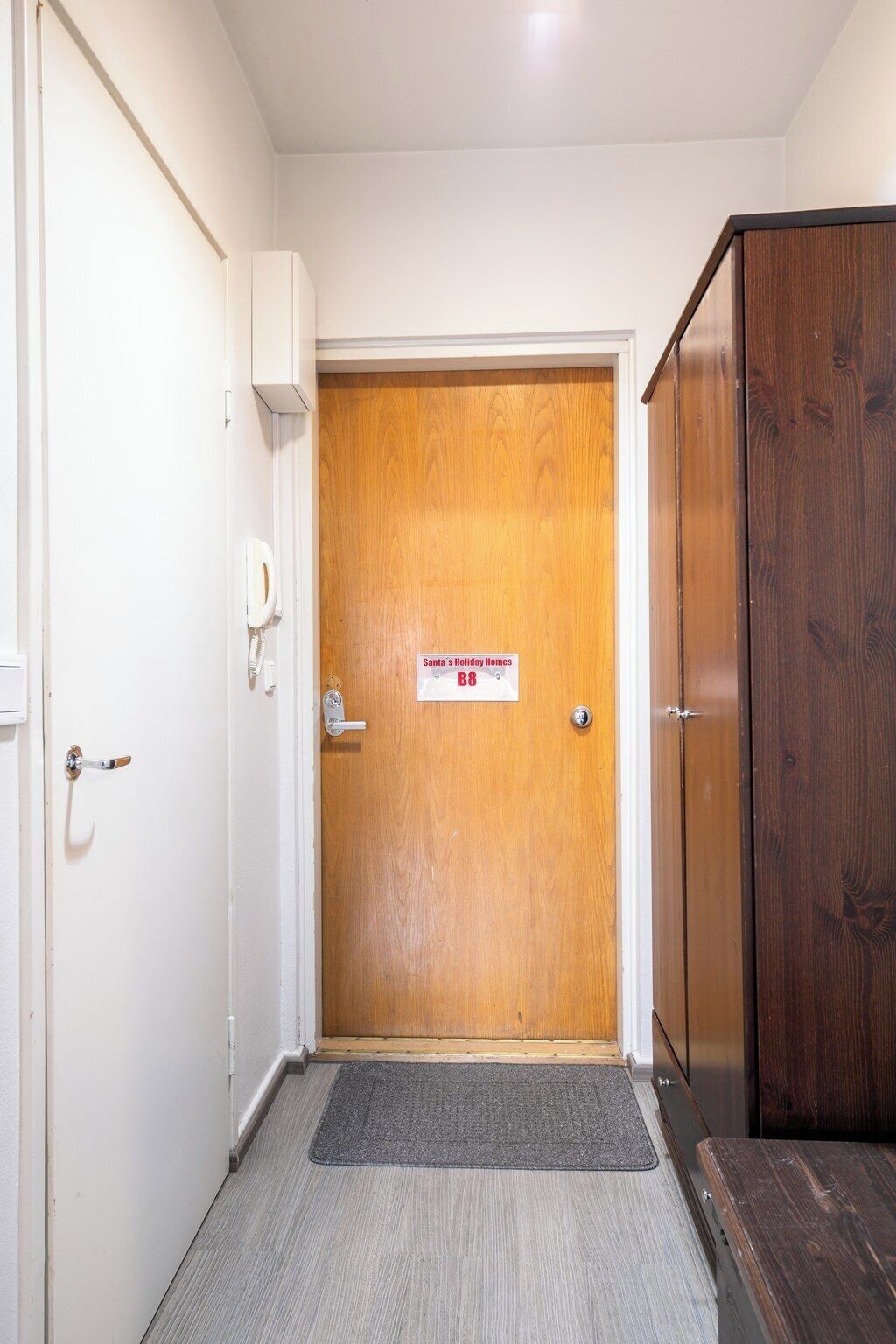 Un pasillo con una puerta de madera que dice 'Santa's Holiday Homes B8'.
